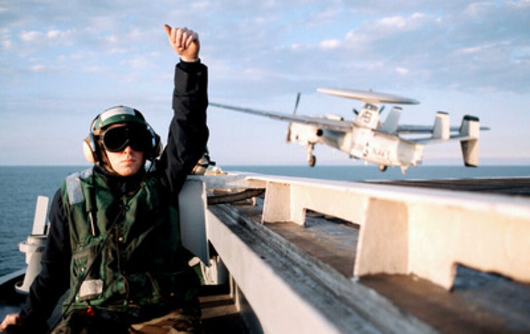 Airman Brian Nestby gives the thumbs up after a successful E-2C Hawkeye launch from the flight deck of the USS George Washington (CVN 73) as the ship steams in the Persian Gulf on Feb. 18, 1998. The Washington battle group is operating in the Persian Gulf in support of Operation Southern Watch which is the U.S. and coalition enforcement of the no-fly-zone over Southern Iraq. Nestby is from Dubuque, Iowa. 