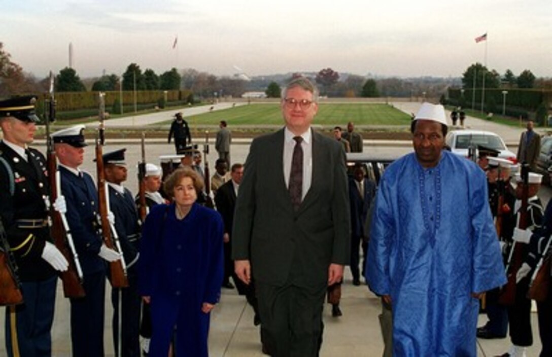 Deputy Secretary of Defense John J. Hamre (center) escorts President Alpha Oumar Konare (right), of the Republic of Mali, through an armed forces honor cordon into the Pentagon on Nov. 21, 1997. 