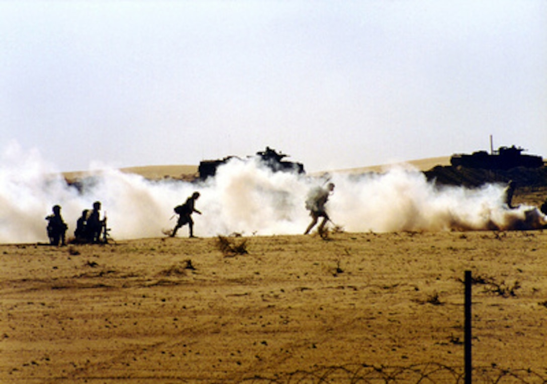Marines from the 13th Marine Expeditionary Unit use smoke to camouflage their movement as they attack Hill #163 in Kuwait during Exercise Eager Mace 98 on Dec. 15, 1997. Eager Mace 98 is a joint, combined, amphibious, ground, air, and naval training exercise with U.S. and Kuwaiti armed forces. 