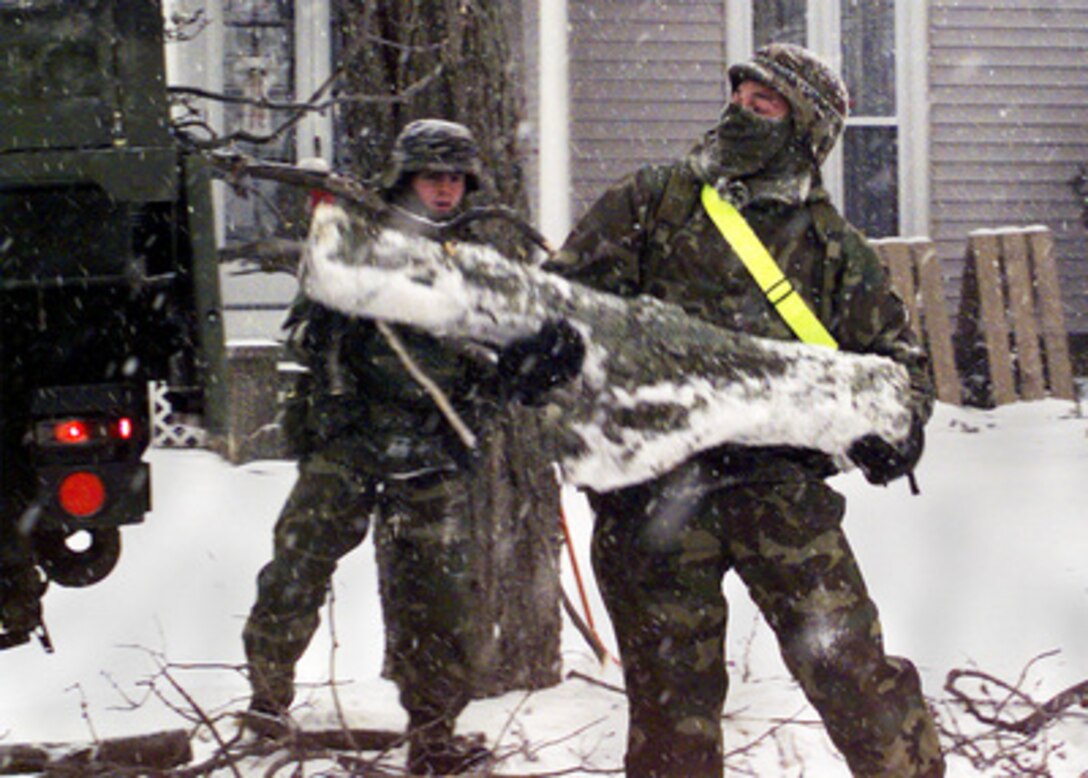 U.S. Army Pfc. Luis Torres (right) throws a section of log into an Army truck as he helps remove a fallen tree from a yard in Copenhagen, N.Y., on Jan. 15, 1998. Numerous trees were damaged from heavy ice buildup following a January 8th ice storm which left thousands of upstate New York people without electrical power or heat. Personnel from Fort Drum are working around the clock in support of communities crippled by the recent ice storm. Soldiers are augmenting community clean-up efforts and providing trucks, electrical power, mobile kitchens, heaters, and more than 60,000 sand bags. Torres is attached to C Company, 1st Battalion, 87th Infantry Regiment. 