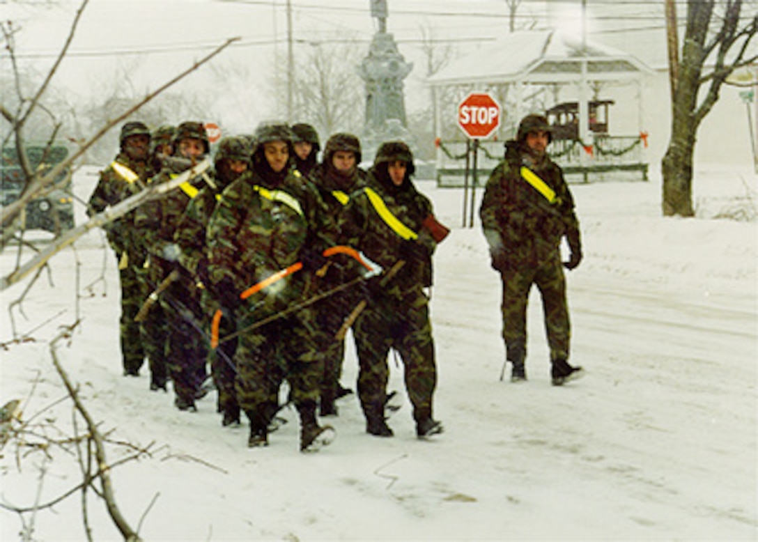 There's no stopping these soldiers from the 10th Mountain Division's 1st Battalion, 87th Infantry Regiment as they march through village of Copenhagen, N.Y. on Jan. 15, 1998. The infantrymen laid down their weapons and picked up axes and hand saws to assist in the clean-up of Copenhagen. Numerous trees were damaged from heavy ice buildup following a January 8th ice storm which left thousands of upstate New York people without electrical power or heat. Personnel from Fort Drum are working around the clock in support of communities crippled by the recent ice storm. Soldiers are augmenting community clean-up efforts and providing trucks, electrical power, mobile kitchens, heaters, and more than 60,000 sand bags. 