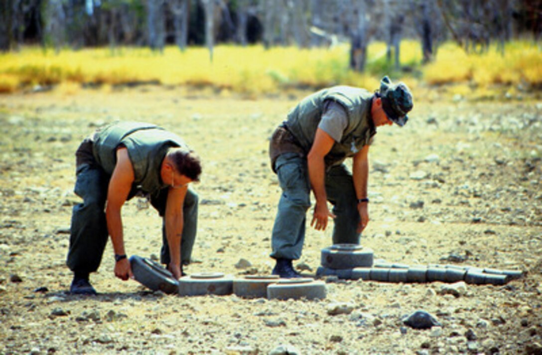 Marine Barracks Minefield Maintenance personnel stack deactivated anti-tank and anti-personnel land mines for destruction at a demolition site on Naval Station Guantanamo Bay, Cuba, in this July 10, 1997, file photo. Anti-personnel and anti-tank land mines on the U.S. side of the fence separating Communist Cuba and the U.S. Naval Base at Guantanamo Bay are being removed in accordance with the Presidential Order of May 16, 1996. Approximately 50,000 land mines were placed in the buffer zone between Communist Cuba and Guantanamo Bay beginning in 1961 as a result of the Cold War. The land mines are being replaced by motion and sound sensors to detect any incursion onto the base. 