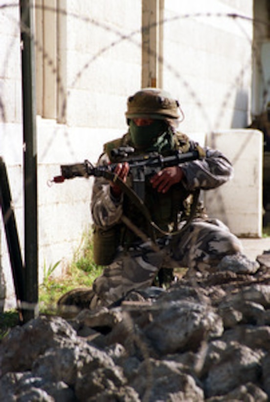 A Charlie Company Marine guards the embassy in the Military Operations in Urban Terrain facility at Camp Lejeune, N.C., on Jan. 21, 1998, during Urban Warrior. Urban Warrior is the U.S. Marine Corps Warfighting Laboratory's series of limited objective experiments examining new urban tactics and experimental technologies. The experiment is being conducted by the Special Purpose Marine Air-Ground Task Force (Experimental) from Quantico, Va., and Charlie Company, 1st Battalion, 6th Marines from Camp Lejeune, with support from the 2nd Marine Expeditionary Force. 