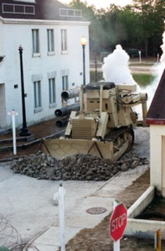 A Joint Amphibious Mine D7G Medium Tracked Bulldozer clears a path through rubble and concertina wire in the Military Operations in Urban Terrain facility at Camp Lejeune, N.C., on Jan. 22, 1998, during Urban Warrior. Urban Warrior is the U.S. Marine Corps Warfighting Laboratory's series of limited objective experiments examining new urban tactics and experimental technologies. The experiment is being conducted by the Special Purpose Marine Air-Ground Task Force (Experimental) from Quantico, Va., and Charlie Company, 1st Battalion, 6th Marines from Camp Lejeune, with support from the 2nd Marine Expeditionary Force. 