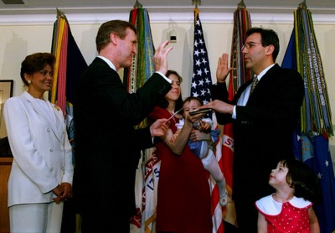 Secretary of Defense William S. Cohen (second from left) administers the oath of office to Secretary of the Army Louis Caldera (right) as his wife Eva (center) holds daughter Sophia and a family Bible at a Pentagon ceremony on July 2, 1998. The Caldera's oldest daughter Allegra (far right) and Mrs. Janet Cohen (far left) watch as Caldera is sworn in as the 17th Army secretary. Caldera was born in El Paso, Texas and raised in Whittier, Calif. 
