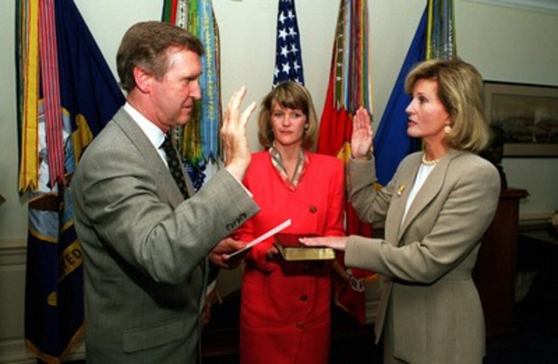 Secretary of Defense William S. Cohen (left) administers the oath of office to Dr. Sue Bailey (right) as the assistant secretary of Defense for Health Affairs as her daughter Mrs. Lee Hults (center) holds the bible in a ceremony at the Pentagon on June 17, 1998. Bailey was nominated by President Clinton for the Health Affairs position on Feb. 24, 1998 and was confirmed by the Senate on May 14, 1998. 