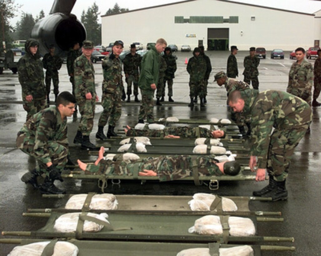 Soldiers from Alpha Company, 133rd Armor Division, Fort Lewis, Wash., acting as litter bearers, position the stretchers for the aeromedical evacuation competition at Air Mobility Rodeo 98, McChord Air Force Base, Wash., June 23, 1998. Rodeo 98 tests the flight and ground skills of aircrews as well as the related skills of special tactics, security forces, aerial porters, aeromedical evacuation and maintenance members. The goal of the international airlift-tanker competition is to develop and improve techniques and procedures that enhance air mobility operations. 