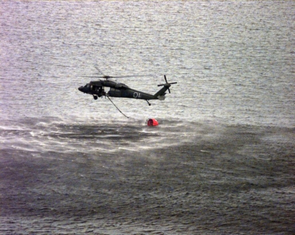 An Army National Guard UH-60 Blackhawk fills a 700 gallon water bucket to fight the forest fires in Palatka, Fla., on July 7, 1998. This is the first time the bucket, commonly known as a Bambi bucket, has been used by the National Guard Blackhawks and their crews from the 1-171 Combat Support Aviation Battalion. The fires have forced thousands of residents to be evacuated from their homes. 