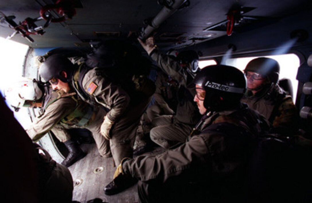 Preparing to fastrope down from a Navy helicopter, Explosive Ordnance Disposal (EOD) technicians from EOD Mobile Unit Two, Whidbey Island, Wash., move to the door. Working with Australian clearance divers, EOD was called to the Canadian ship HMCS Regina to clear a jammed gun mount. The exercise is part of RIMPAC '98 exercises off of Pearl Harbor, Hawaii. RIMPAC '98 is designed to enhance the tactical capabilities of participating units in major aspects of maritime operations at sea. RIMPAC '98 is the sixteenth in a series of Pacific naval exercises. 