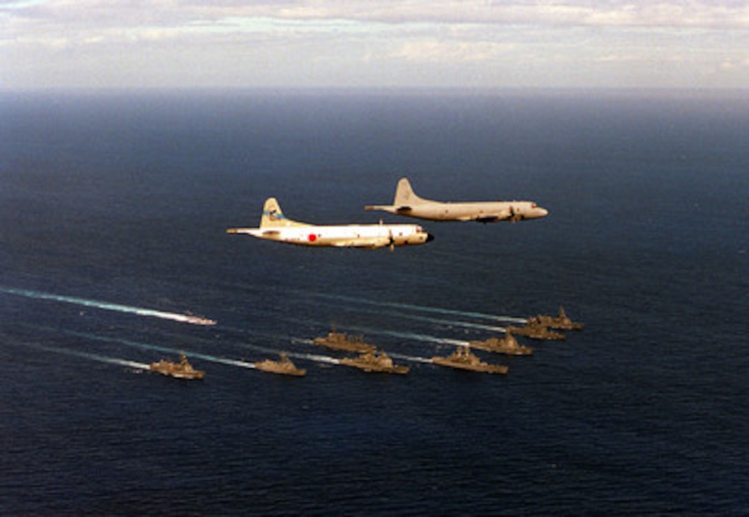 A U.S. Navy P-3 Orion from the Skinny Dragons of Patrol Squadron 4 leads a Japanese P-3 in flight over a bilateral force of U.S. and Japanese ships. The ships in formation are: USS Key West SSN 722, USS Vandergrift FFG 48, USS California CGN 36, USS Chancellorsville CG 62, USS Port Royal CG 73, JDS Kirishima DDG 174, JDS Shirane DDH 143, JDS Murasame DD 101, JDS Harusame DD 102, and JDS Towada AOE 422. The operations are part of RIMPAC '98. RIMPAC '98 is designed to enhance the tactical capabilities of participating units in major aspects of maritime operations at sea. RIMPAC '98 is the sixteenth in a series of Pacific naval exercises. 