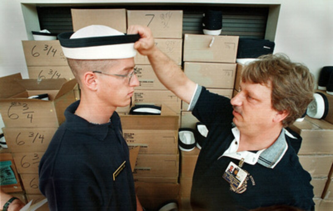 Kevin Maddaford, 18 of Los Angeles Calif., gets fitted for the plebe hat with assistance from U.S. Naval Academy's store personnel, Bruce Fryer. Maddaford is one of the more than 1,200 new arrivals at the academy hoping for a career as a U.S. Naval officer. 