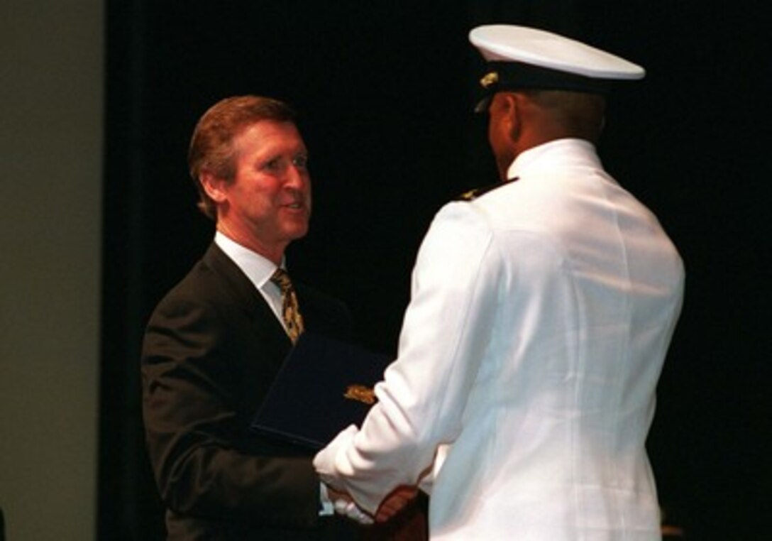 Secretary of Defense William S. Cohen presents a commissioning certificate to an ROTC graduate at the L. Douglas Wilder Center, Norfolk State University, Norfolk, Va., on May 16, 1998. Cohen visited NSU to kick off the nation's 50th anniversary observance of President Harry S. Truman's executive order desegregating the armed forces. 