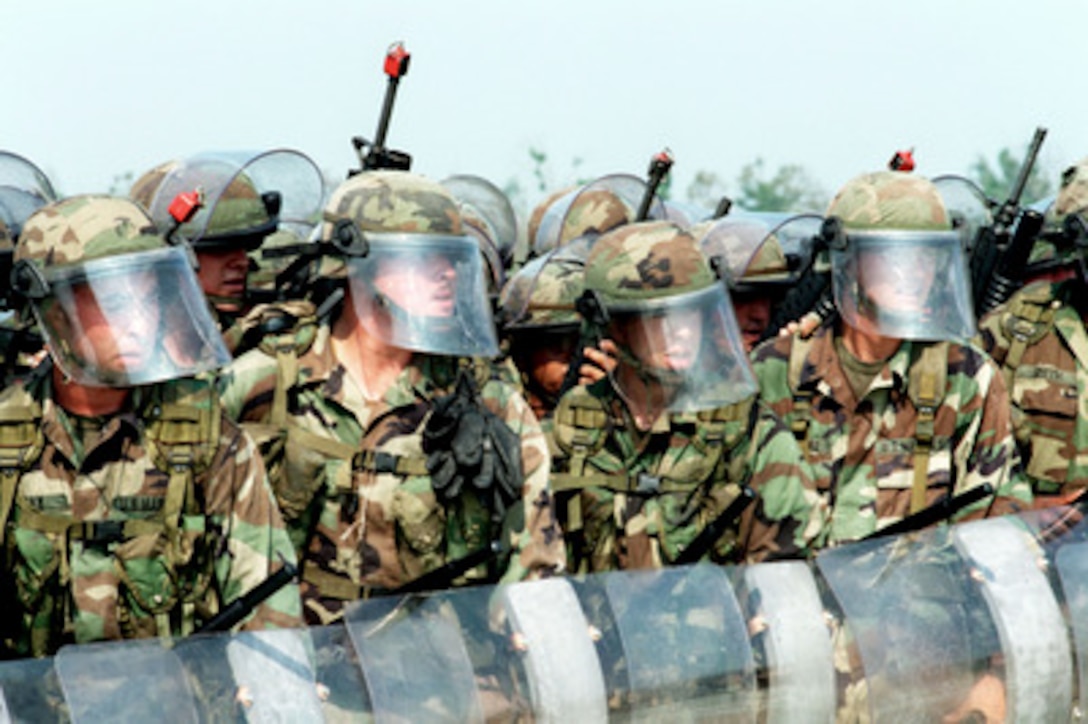 U.S. Marines in riot gear build a human wall as they demonstrate one of the ways for handling an uncontrollable crowd in a riot control class as part of Exercise Cooperative Osprey '98 at Marine Corps Base, Camp Lejeune, N.C., on June 4, 1998. Cooperative Osprey '98 is a Partnership for Peace situational training exercise designed to improve the interoperability of NATO and partner nations through the practice of combined peacekeeping and humanitarian relief operations. Partner nations include Albania, Bulgaria, Estonia, Georgia, Kazakstan, Kyrgyzstan, Latvia, Lithuania, Moldova, Poland, Romania, Ukraine, and Uzbekistan. Participating NATO nations include Canada, The Netherlands, and the United States. 