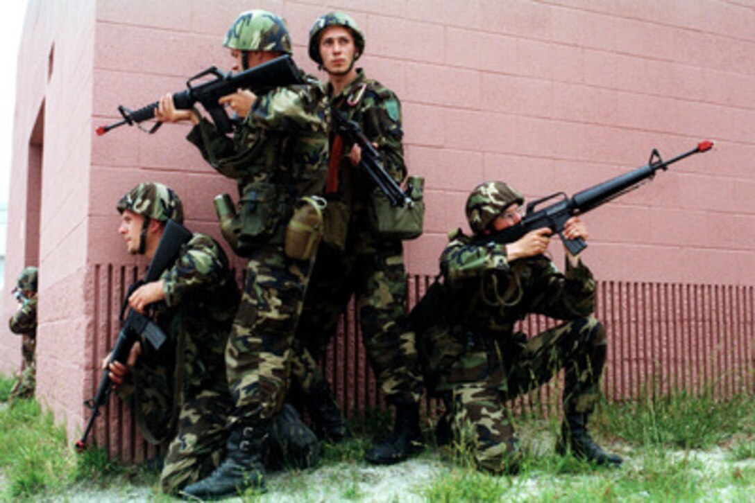Four Latvian soldiers keep a sharp look out as they pause before rounding the corner of a building in the Military Operations in Urban Terrain facility at Camp Lejeune, N.C., on June 5, 1998, during Exercise Cooperative Osprey '98. Cooperative Osprey '98 is a Partnership for Peace situational training exercise designed to improve the interoperability of NATO and partner nations through the practice of combined peacekeeping and humanitarian relief operations. Partner nations include Albania, Bulgaria, Estonia, Georgia, Kazakstan, Kyrgyzstan, Latvia, Lithuania, Moldova, Poland, Romania, Ukraine, and Uzbekistan. Participating NATO nations include Canada, The Netherlands, and the United States. 