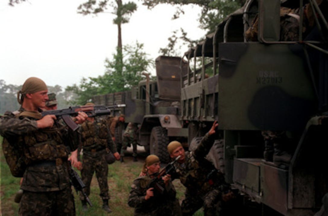 Ukrainian soldiers keep their weapons trained on the door as one soldier searches a Bulgarian truck during training as part of Exercise Cooperative Osprey '98 on June 6, 1998, at Marine Corps Base, Camp Lejeune, N.C. Cooperative Osprey '98 is a Partnership for Peace situational training exercise designed to improve the interoperability of NATO and partner nations through the practice of combined peacekeeping and humanitarian relief operations. Partner nations include Albania, Bulgaria, Estonia, Georgia, Kazakstan, Kyrgyzstan, Latvia, Lithuania, Moldova, Poland, Romania, Ukraine, and Uzbekistan. Participating NATO nations include Canada, The Netherlands, and the United States. 