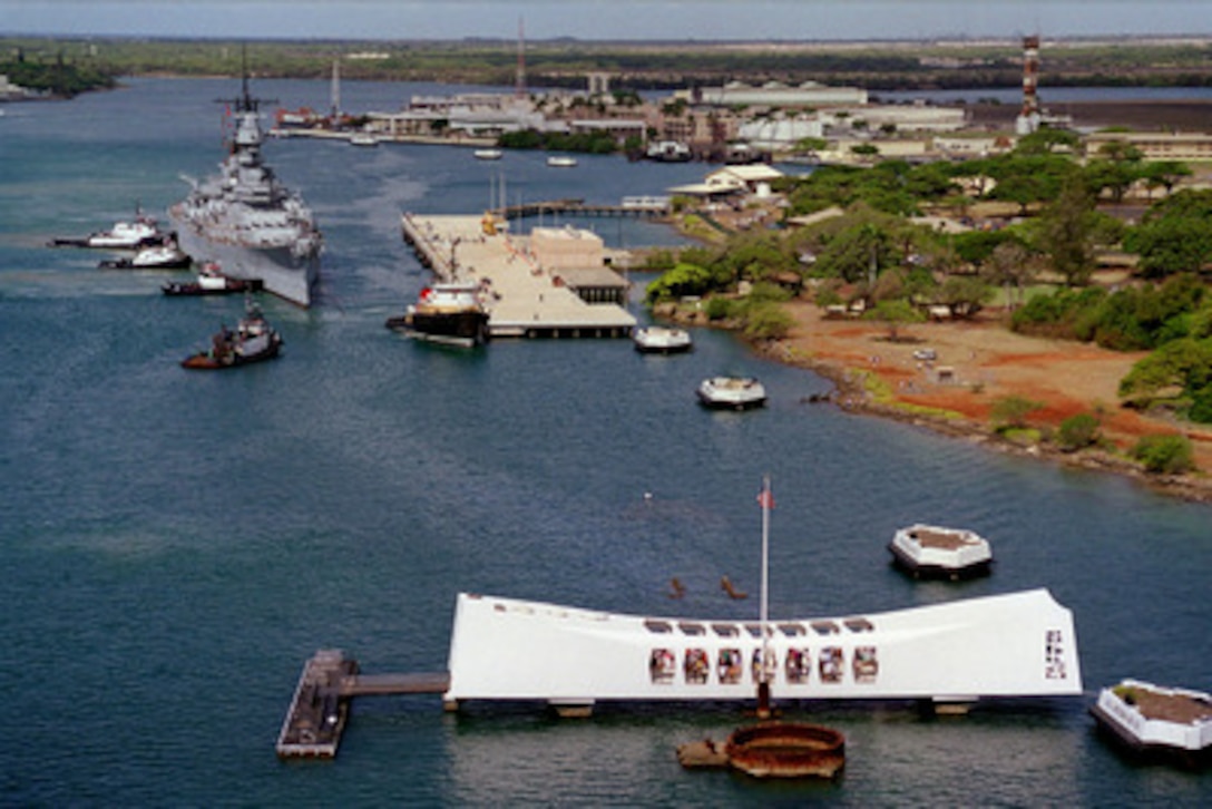 Tug boats push the battleship USS Missouri (BB 63) to its new berth at Ford Island, on June 22, 1998, as it joins the USS Arizona Memorial (foreground) in Pearl Harbor, Hawaii. Secretary of the Navy John H. Dalton signed the Donation Agreement on May 4th, allowing Missouri to be used as a museum near the Arizona Memorial as symbols of the beginning and the end of World War II. The Missouri was towed 2,600-miles across the Pacific Ocean from Bremerton, Wash. 