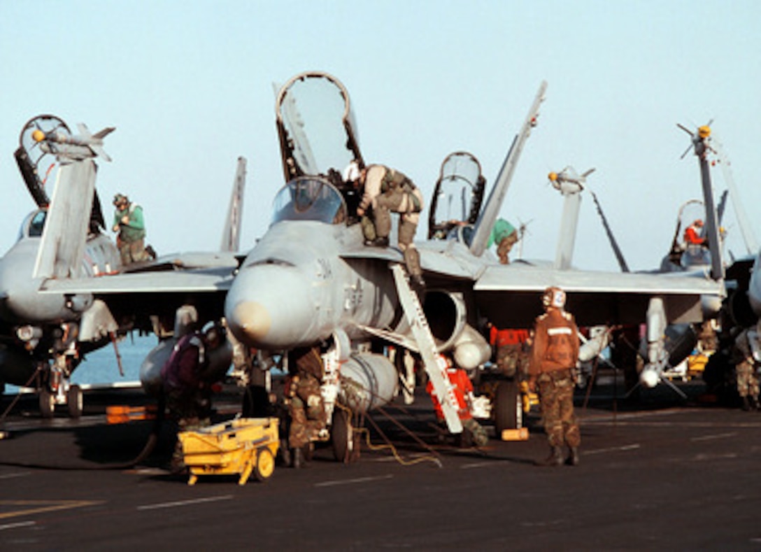 A Marine pilot climbs into an F/A-18C Hornet being readied for flight aboard the aircraft carrier USS George Washington (CVN 73 as the ship steams in the Persian Gulf on Feb. 19, 1998. The Washington battle group is operating in the Persian Gulf in support of Operation Southern Watch which is the U.S. and coalition enforcement of the no-fly-zone over Southern Iraq. The pilot and his aircraft are attached to Marine Fighter-Attack Squadron 251 of Marine Corps Air Station Beaufort, S.C. 