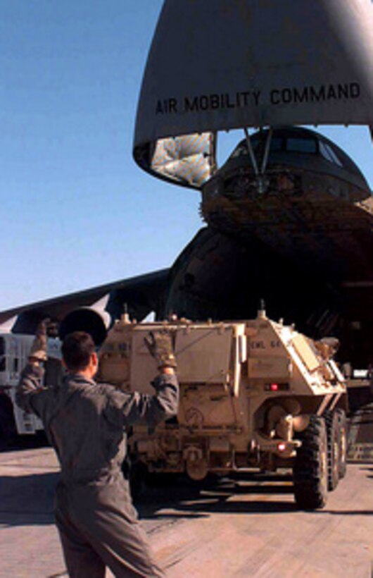 A U.S. Air Force C-5 Galaxy loadmaster guides a U.S. Army M93A1 Fox nuclear, biological, and chemical reconnaissance systems vehicle out of a Galaxy at an operating base in Southwest Asia on Feb. 19, 1998, during Operation Southern Watch. Southern Watch is the U.S. and coalition enforcement of the no-fly-zone over southern Iraq. The Fox vehicle is deployed to the Gulf region from the 92nd Chemical Company, Fort Stewart, Ga. 