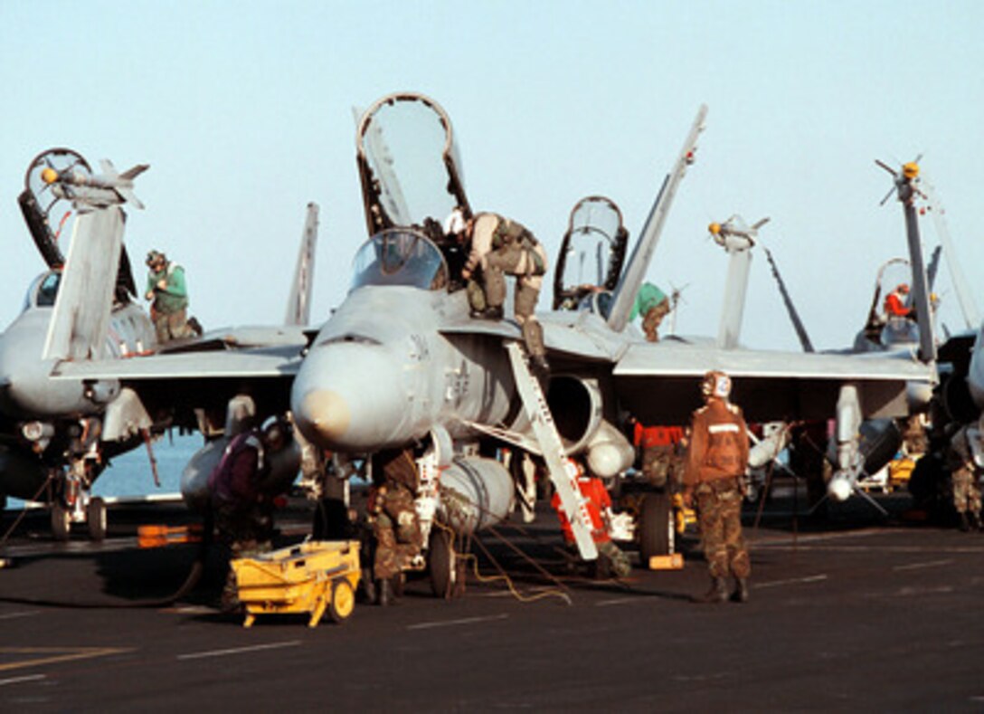 A Marine pilot climbs into an F/A-18C Hornet being readied for flight aboard the aircraft carrier USS George Washington (CVN 73 as the ship steams in the Persian Gulf on Feb. 19, 1998. The Washington battle group is operating in the Persian Gulf in support of Operation Southern Watch which is the U.S. and coalition enforcement of the no-fly-zone over Southern Iraq. The pilot and his aircraft are attached to Marine Fighter-Attack Squadron 251 of Marine Corps Air Station Beaufort, S.C. 