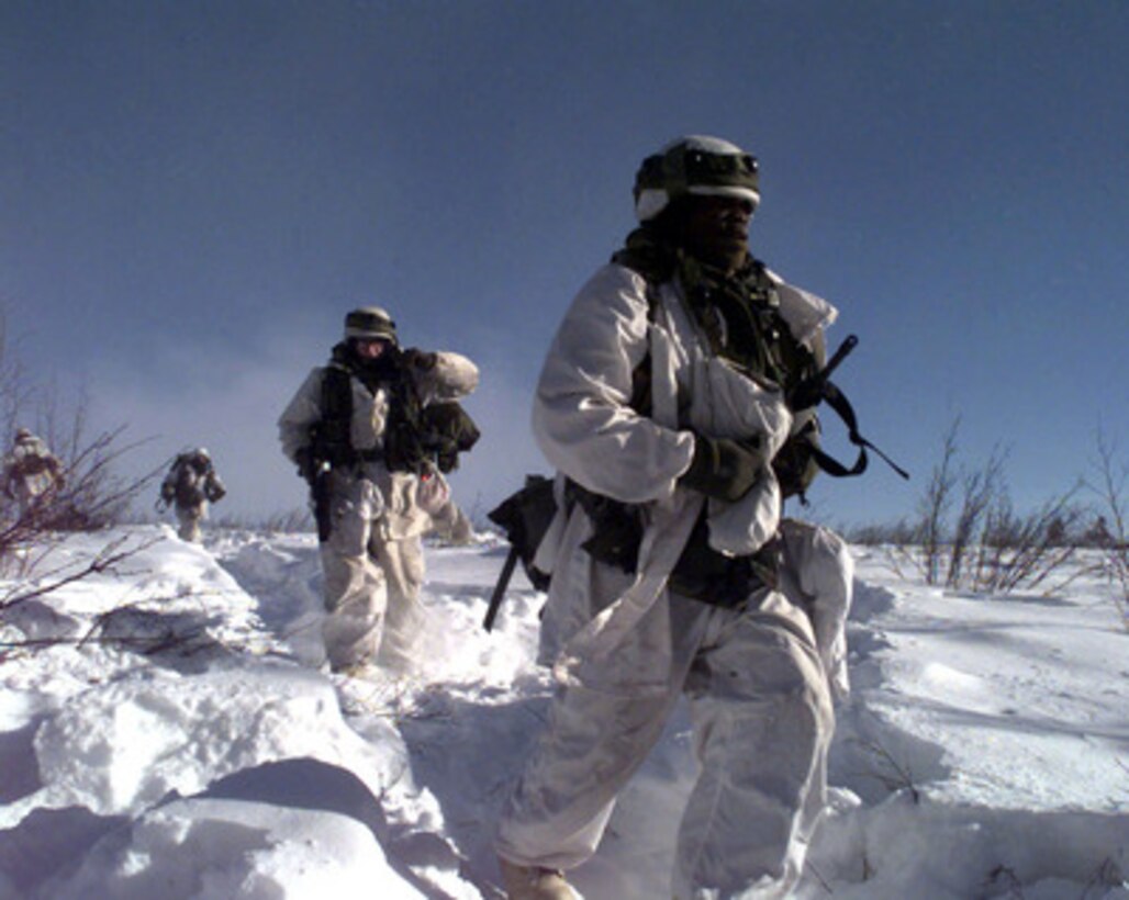 Soldiers from the 2nd Battalion, 1st Infantry move out as they conduct a patrol near their objective of the village of Simpsonville at Fort Greeley, Alaska on Feb. 19, 1998, during Exercise Northern Edge 98. More than 90,000 soldiers, sailors, Marines, airmen Coast Guardsmen and National Guardsmen are participating the exercise. Northern Edge 98 is designed to practice joint operational techniques and procedures, increasing interoperability between the services. 