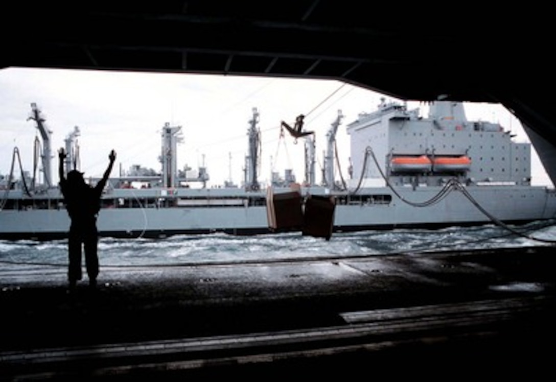 Petty Officer 3rd Class Christian Kerlick signals the winch operators on the oiler USNS Guadeloupe (TAO-200) from the hanger deck of the aircraft carrier USS George Washington (CVN 73) as the ships steam side-by-side during an underway replenishment operation in the Persian Gulf on Feb. 21, 1998. The Washington battle group is operating in the Persian Gulf in support of Operation Southern Watch which is the U.S. and coalition enforcement of the no-fly-zone over Southern Iraq. Kerlick, from Wichita Falls, Texas, is a Navy boatswain's mate. The USNS Guadeloupe is a Military Sea Lift Command ship. 