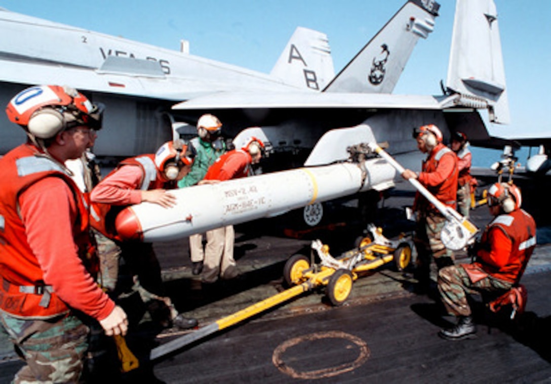 Aviation ordnancemen load an AGM-84E Standoff Land-Attack Missile onto an F/A-18C Hornet on the flight deck of the aircraft carrier USS George Washington (CVN 73) as the ship steams in the Persian Gulf on Feb. 20, 1998. The Washington battle group is operating in the Persian Gulf in support of Operation Southern Watch which is the U.S. and coalition enforcement of the no-fly-zone over Southern Iraq. From left to right are: David Dorris, from Jacksonville, Fla., Joel Kopp, from Ransomville, N.Y., Keith Collins, from Glen St. Mary, Fla., Alvin Toney, from Worchester, Mass., and Hector Hernandez. The Hornet is from Strike Fighter Squadron 86, Naval Air Station Cecil Field, Fla. 