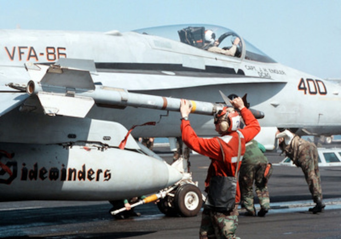 U.S. Marine Corps Lance Cpl. Leander Pickens arms an AIM-9 Sidewinder missile on a F/A-18C Hornet as the aircraft is readied for launch from the aircraft carrier USS George Washington (CVN 73) as the ship steams in the Persian Gulf on Feb. 20, 1998. The Washington battle group is operating in the Persian Gulf in support of Operation Southern Watch which is the U.S. and coalition enforcement of the no-fly-zone over Southern Iraq. Pickens is from Greenville, Ala. The Hornet is from Strike Fighter Squadron 86, Naval Air Station Cecil Field, Fla. 