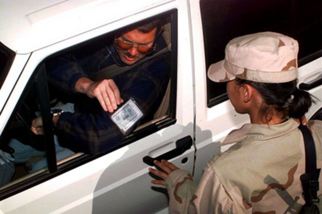 Airman Mary Ann Hubany, a security forces specialist, checks a driver's military identification card for positive identification before allowing the vehicle to enter the U.S. military compound at an operating base in Southwest Asia on February 23, 1998. Airmen assigned to the 4406th Security Forces Squadron (provisional) are providing force and resource protection as part of a force augmentation in Southwest Asia. Hubany is deployed from the 42nd Security Forces Squadron, Maxwell Air Force Base, Ala. 
