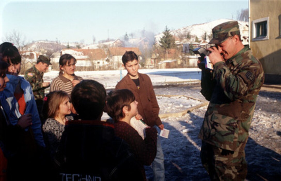 U.S. Air Force Staff Sgt. Neil Rothbauer takes pictures of children living at the Mother and Child Refugee Center in Simin Han, Bosnia and Herzegovina, on Jan. 30, 1998. The center houses refugees from Srebrenica, whose fathers were killed or missing from the Balkan Conflicts. Rothbauer, along with members from the 401st Expeditionary Air Base Group out of Tuzla Air Base, volunteered to deliver donations of toys, food and clothing to help the people living at the refugee center. Rothbauer is a power production journeyman assigned to the 401st Expeditionary Air Base Group as part of the Stabilization Force in Operation Joint Guard. 