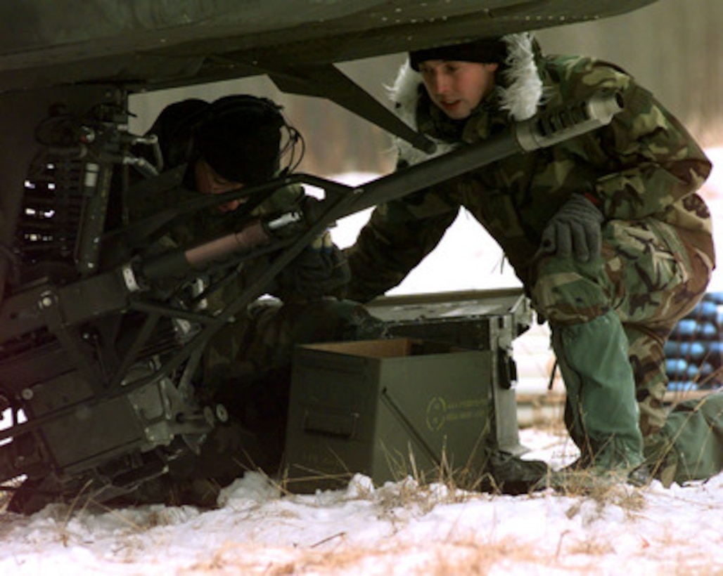Sgt. Richard Colon (left) and Pfc. James Sonnier (right) load 30 mm rounds into a 30 mm cannon mounted underneath a U.S. Army AH-64 Apache helicopter on Feb. 28, 1998, during Exercise Northern Edge 98. More than 90,000 soldiers, sailors, Marines, airmen, Coast Guardsmen and National Guardsmen are participating the exercise. Northern Edge 98 is designed to practice joint operational techniques and procedures, increasing interoperability between the services. The Apache and the soldiers are attached to the 4th Battalion, 3rd Armored Cavalry Regiment, Fort Carson, Colo. 