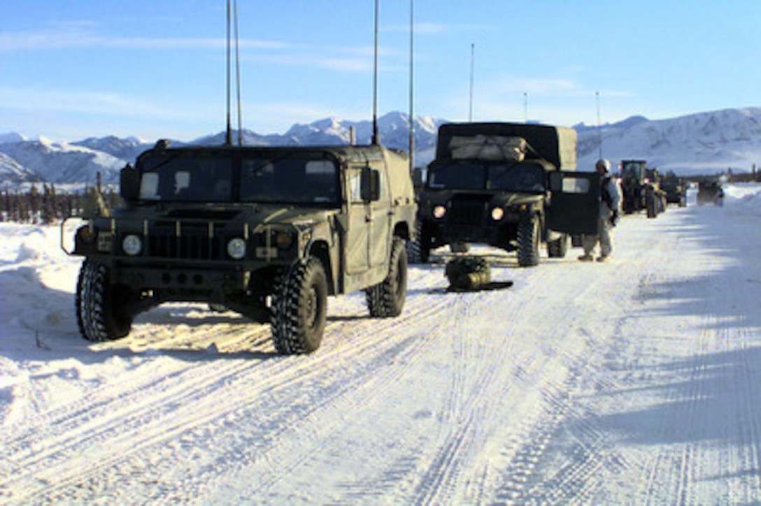 A caravan of U.S. Army Humvees and heavy equipment forms up on a snow-covered road at Fort Greely, Alaska, on Feb. 19, 1998, during Exercise Northern Edge 98. More than 90,000 soldiers, sailors, Marines, airmen, Coast Guardsmen and National Guardsmen are participating the exercise. Northern Edge 98 is designed to practice joint operational techniques and procedures, increasing interoperability between the services. 