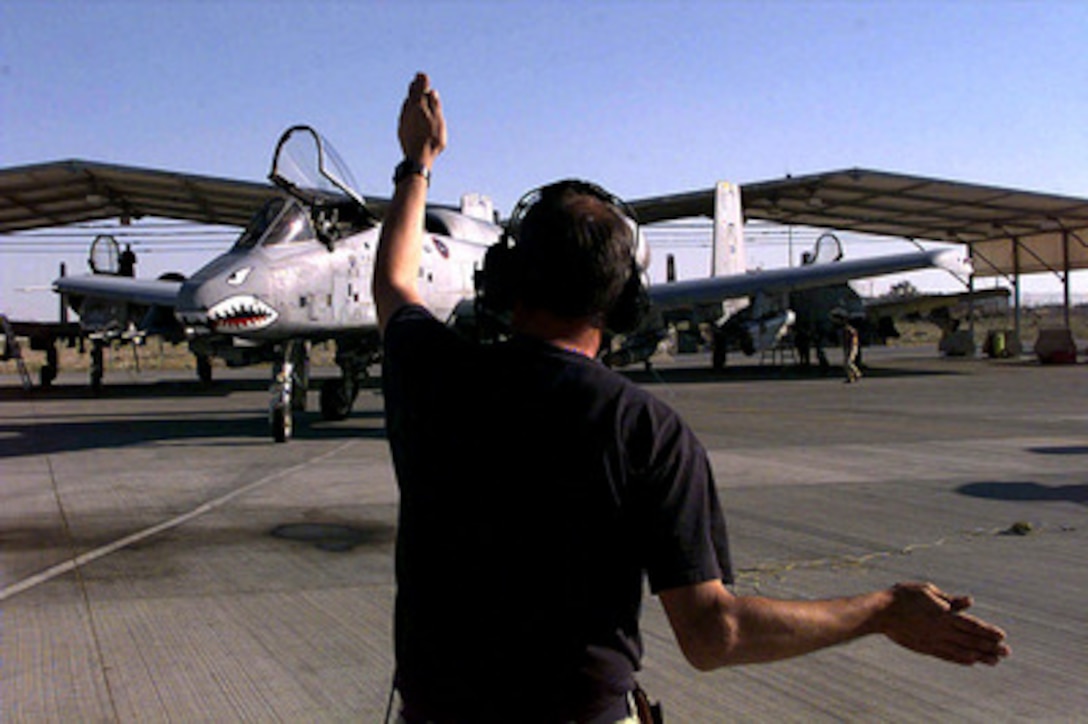 Staff Sgt. Edward Evans guides an A-10 Thunderbolt to its parking position after its return from patrolling the no-fly-zone over Southern Iraq on Feb. 27, 1998, in support of Operation Southern Watch. Evans is a Thunderbolt crew chief assigned to the 74th Fighter Squadron deployed from the 23rd Fighter Group, Pope Air Force Base, N.C. The A-10's of the 74th have been flying the zone since 1994 in support of Southern Watch. 