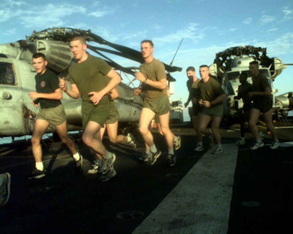 U.S. Marines from 3rd Platoon, India Company, perform morning physical training on the flight deck of the USS Guam (LPH-9) as the ship steams in the Persian Gulf on Feb. 28, 1998. The Guam and its embarked, combat-ready Marines from the 24th Marine Expeditionary Unit (Special Operations Capable) are operating in the Persian Gulf as part of a force augmentation in Southwest Asia. The Guam is homeported in Norfolk, Va. 