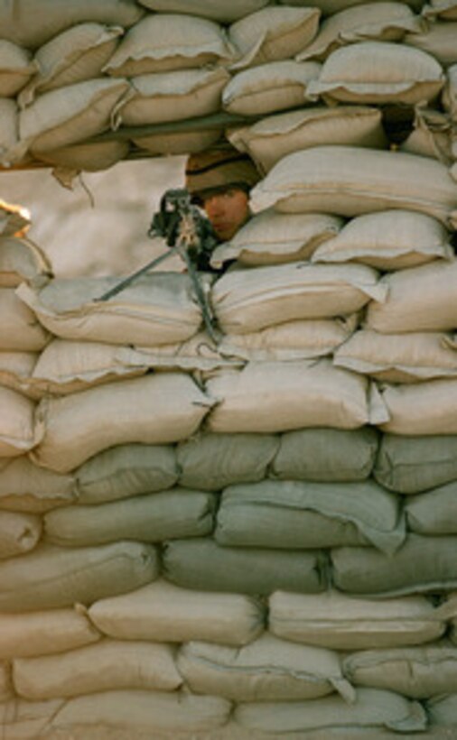 Pvt. Daniel McCullough stands guard duty at a U.S. Army checkpoint in the Kuwaiti desert on March 2, 1998. McCullough and his fellow soldiers of the 92nd Chemical Company, Fort Stewart, Ga., are deployed to Kuwait as part of a force augmentation in Southwest Asia. 