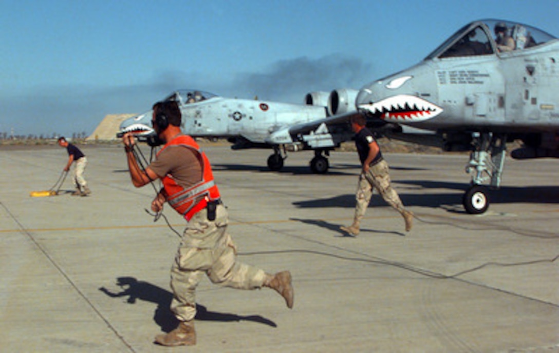 U.S. Air Force A-10A Thunderbolt ground crewmen run from the aircraft after performing final inspections and giving approval to launch from Ahmed Al-Jaber Air Base, Kuwait, on March 12, 1998, for a combat patrol mission over Iraq. The Thunderbolts of the 74th Fighter Squadron are deployed from the 23rd Fighter Group, Pope Air Force Base, N.C. The A-10's of the 74th have been flying since 1994 in support of Operation Southern Watch, which is the U.S. and coalition enforcement of the no-fly-zone over Southern Iraq. 