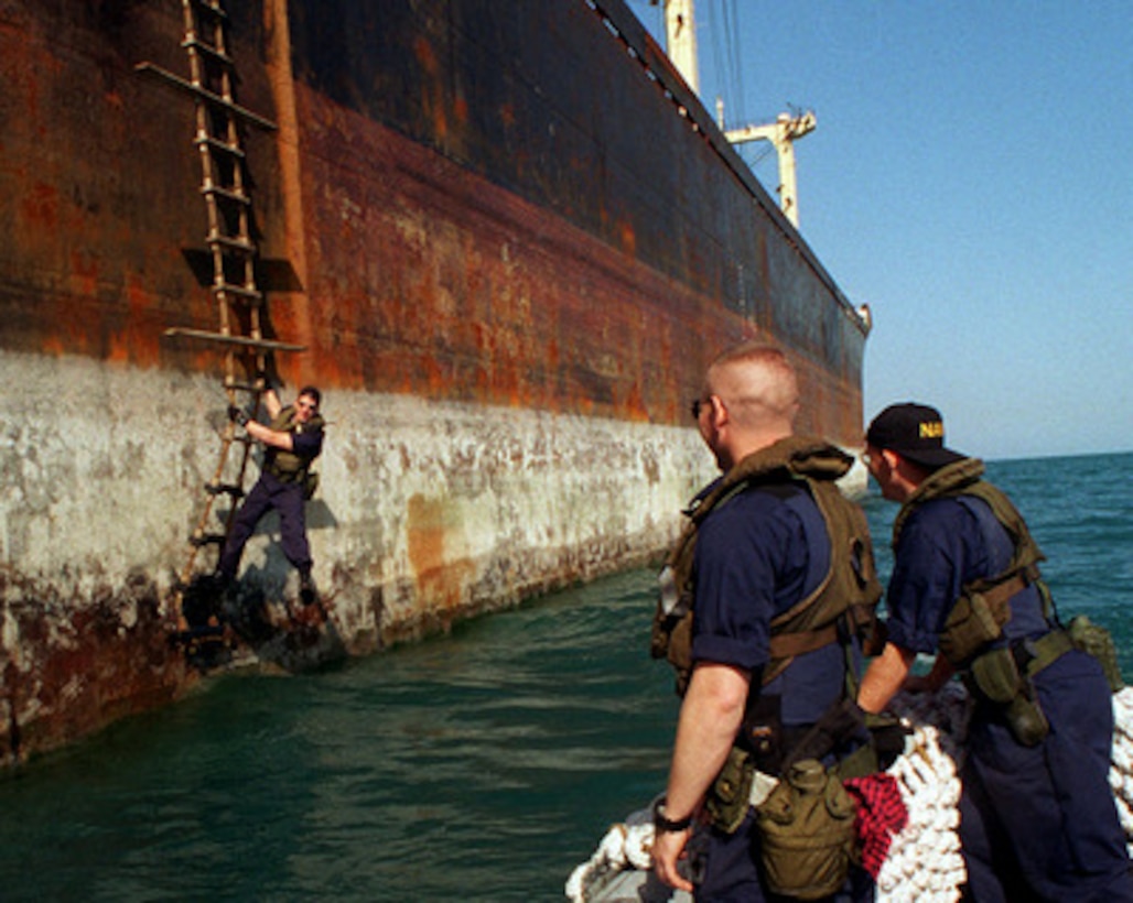 Petty Officer Second Class Clint Foster clings to the Jacob's ladder of an Iranian cargo ship waiting for pick up after a maritime interdiction operation in the Persian Gulf on March 6, 1998. Crew members from the USS John S. McCain (DDG-56) boarded and inspected the ship for possible contraband. The Arleigh Burke class destroyer is conducting the interception operations as part of a force augmentation in the region. The McCain is home ported in Yokosuka, Japan. 
