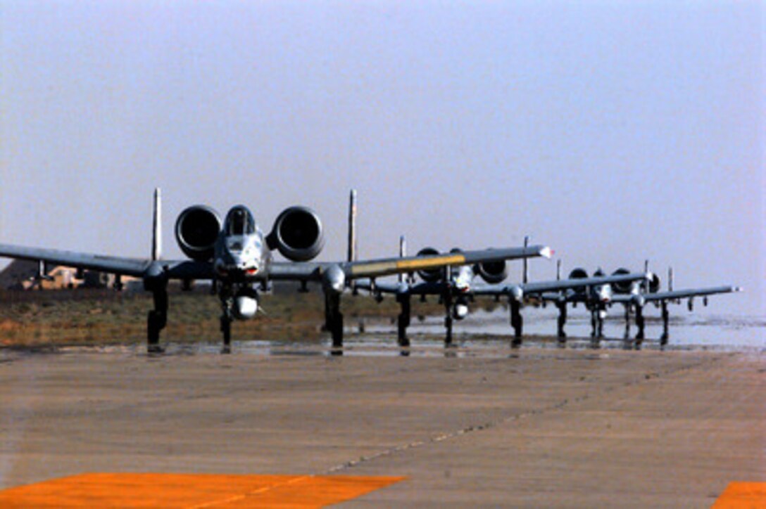 Four U.S. Air Force A-10A Thunderbolts shimmer in the desert heat waves as they taxi out for a combat patrol mission over Iraq from the Ahmed Al-Jaber Air Base, Kuwait, on March 12, 1998. The Thunderbolts of the 74th Fighter Squadron are deployed from the 23rd Fighter Group, Pope Air Force Base, N.C. The A-10's of the 74th have been flying since 1994 in support of Operation Southern Watch, which is the U.S. and coalition enforcement of the no-fly-zone over Southern Iraq. 