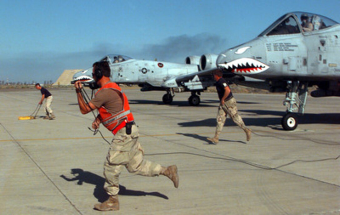 U.S. Air Force A-10A Thunderbolt ground crewmen run from the aircraft after performing final inspections and giving approval to launch from Ahmed Al-Jaber Air Base, Kuwait, on March 12, 1998, for a combat patrol mission over Iraq. The Thunderbolts of the 74th Fighter Squadron are deployed from the 23rd Fighter Group, Pope Air Force Base, N.C. The A-10's of the 74th have been flying since 1994 in support of Operation Southern Watch, which is the U.S. and coalition enforcement of the no-fly-zone over Southern Iraq. 