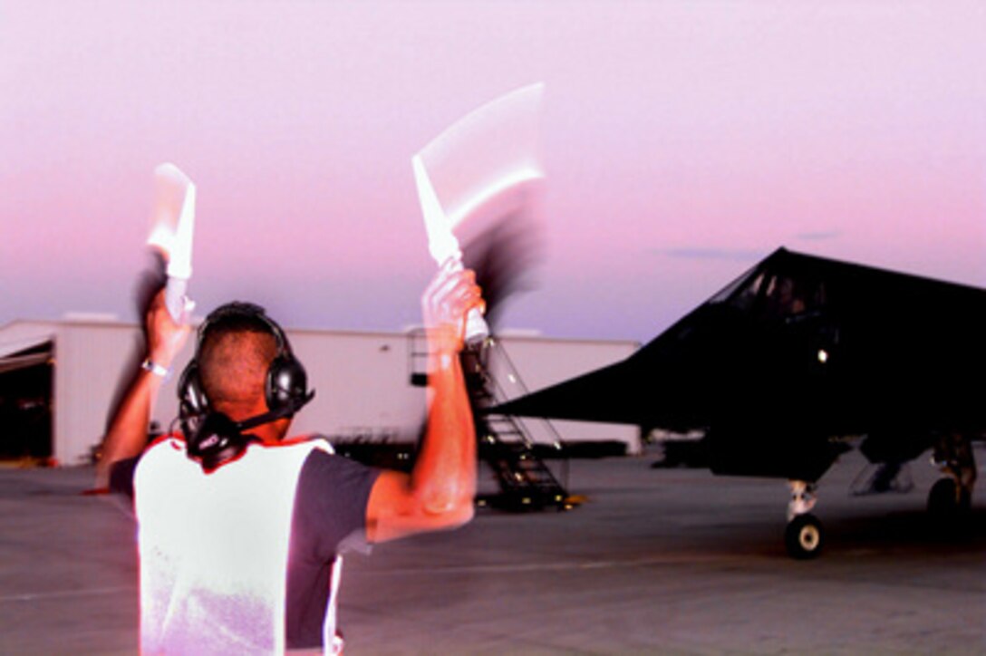 A crew chief directs a U.S. Air Force F-117A Nighthawk onto the taxi way in preparation for launch on combat patrol mission over Iraq on March 13, 1998. Nighthawk stealth fighters are deployed to Al Jaber Air Base, Kuwait, in support of Operation Southern Watch which is the U.S. and coalition enforcement of the no-fly-zone over Southern Iraq. The Nighthawk is attached to the 8th Fighter Squadron, 49th Fighter Wing, Holloman Air Force Base, N.M. 