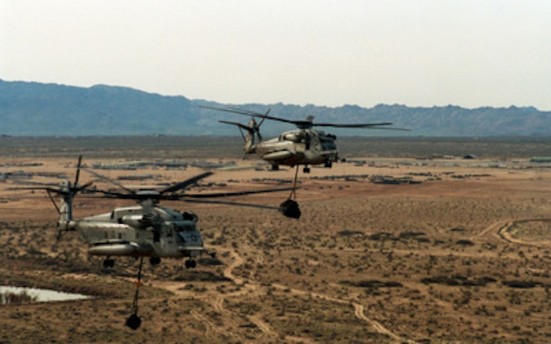U.S. Marine Corps CH-53E Super Stallion helicopters carry a sling load of ammunition and other supplies forward in support of infantry units at the Marine Corps Air Ground Combat Center, Twentynine Palms, Calif., on Feb. 20, 1998. These helicopters and the Marines from Helicopter Light Squadron 364 are taking part in Combined Arms Exercise 4-98. 