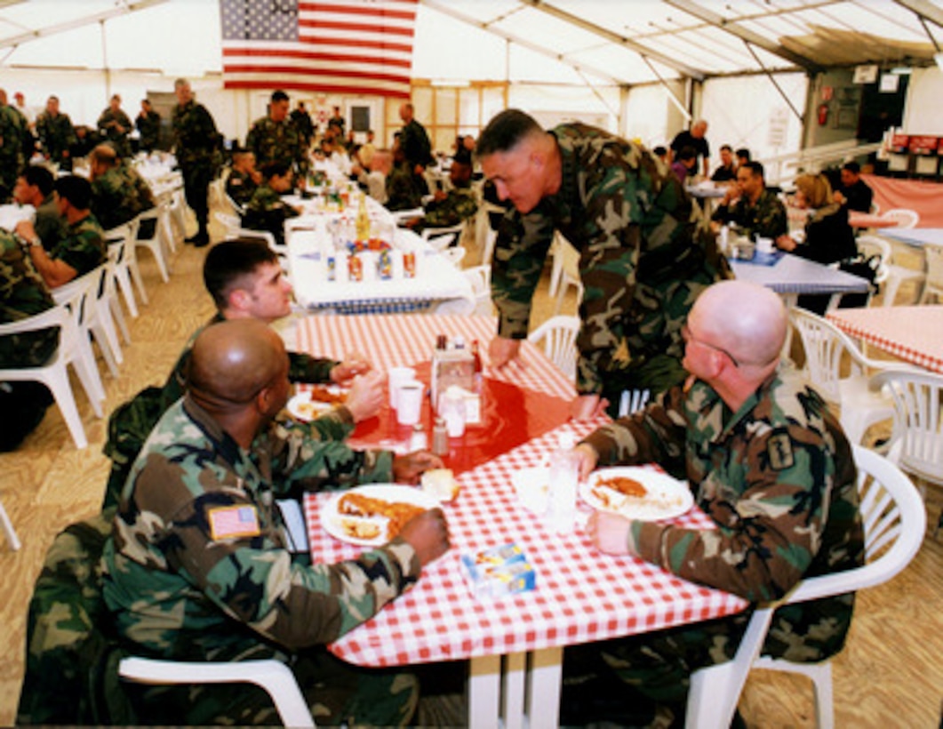 Chairman of the Joint Chiefs of Staff Gen. Henry H. Shelton, U.S. Army, (standing) visits with soldiers at the Taszár Air Base, Hungary, dining facility on April 13, 1998. Shelton's visit is giving the soldiers an opportunity to share their concerns, such as quality of life, directly with the Chairman. Taszár is the intermediate staging base for Operation Joint Guard and the headquarters for the National Support Element. 