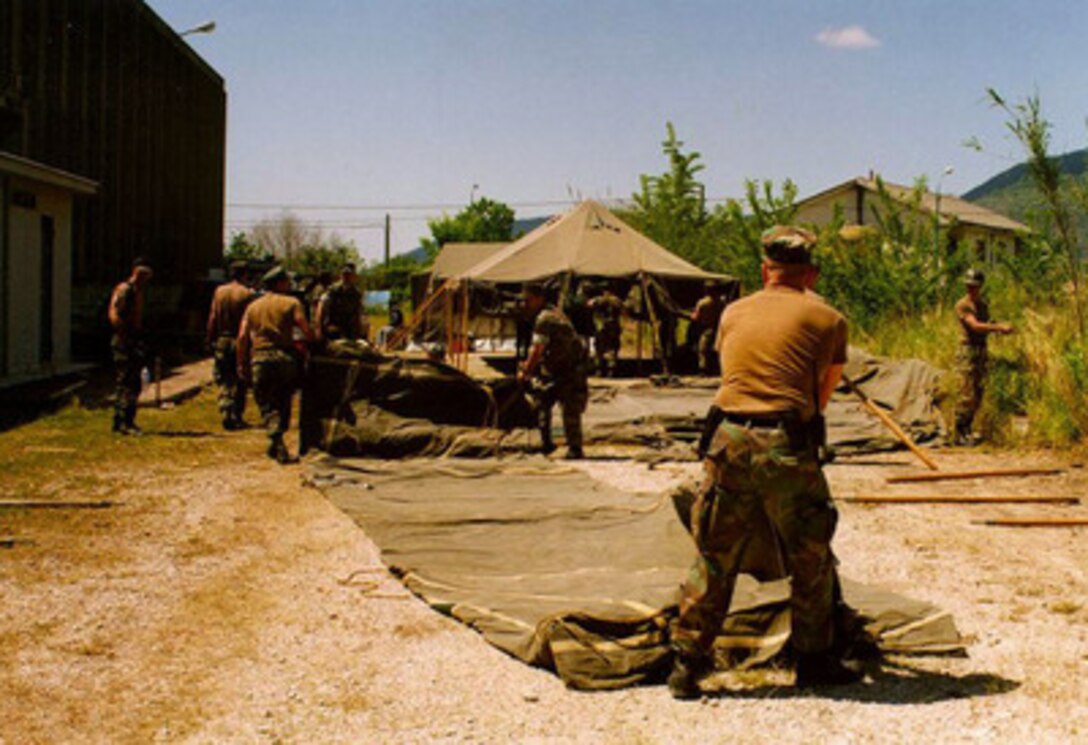 U.S. Navy Seabees from Naval Support Activity, Naples, Italy, begin setting up another tent in Lauro, Italy, on May 8, 1998. The Seabees are setting up 16 tents to shelter Italian relief workers who were aiding the citizens of Quindici, Italy, after last week's mud slides. 