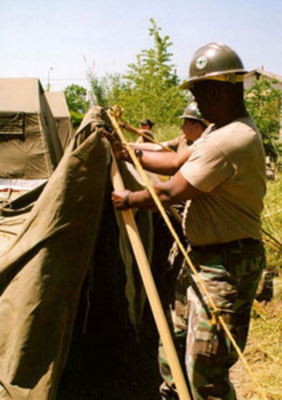 U.S. Navy Seabees from Naval Support Activity, Naples, Italy, begin setting up another tent in Lauro, Italy, on May 8, 1998. The Seabees are setting up 16 tents to shelter Italian relief workers who were aiding the citizens of Quindici, Italy, after last week's mud slides. 