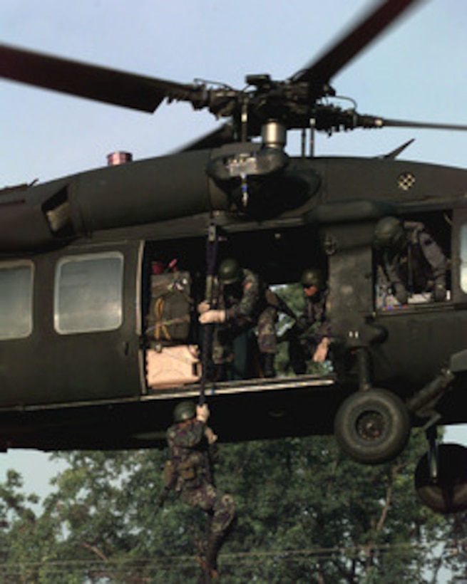 Soldiers of the 1st Special Forces Regiment, Royal Thai Army, fast-rope down from a UH-60 Blackhawk helicopter at Camp Pawai, Thailand, on May 17, 1998, during Exercise Cobra Gold '98. Cobra Gold '98 is the latest in a continuing series of U.S.-Thai military exercises designed to ensure regional peace and strengthen the ability of the Royal Thai Armed Forces to defend Thailand. The training includes joint combined air, land and sea operations. Cobra Gold is the largest strategic mobility exercise involving the U.S. Pacific Command forces this year. The Thai soldiers are cross training with U.S. Army soldiers of Bravo Company, 3rd Battalion, 1st Special Forces Group (Airborne), Fort Lewis, Wash. 