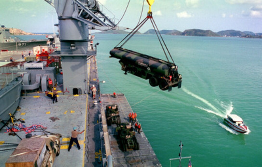 Sailors and Marines guide a tanker trailer as it is lowered over the side of the SS Gopher State (TACS 4) to a lighter craft in Sattahip, Thailand, on May 12, 1998, for use in Exercise Cobra Gold '98. Cobra Gold '98 is the latest in a continuing series of U.S.-Thai military exercises designed to ensure regional peace and strengthen the ability of the Royal Thai Armed Forces to defend Thailand. The training includes joint combined air, land and sea operations. Cobra Gold is the largest strategic mobility exercise involving the U.S. Pacific Command forces this year. 