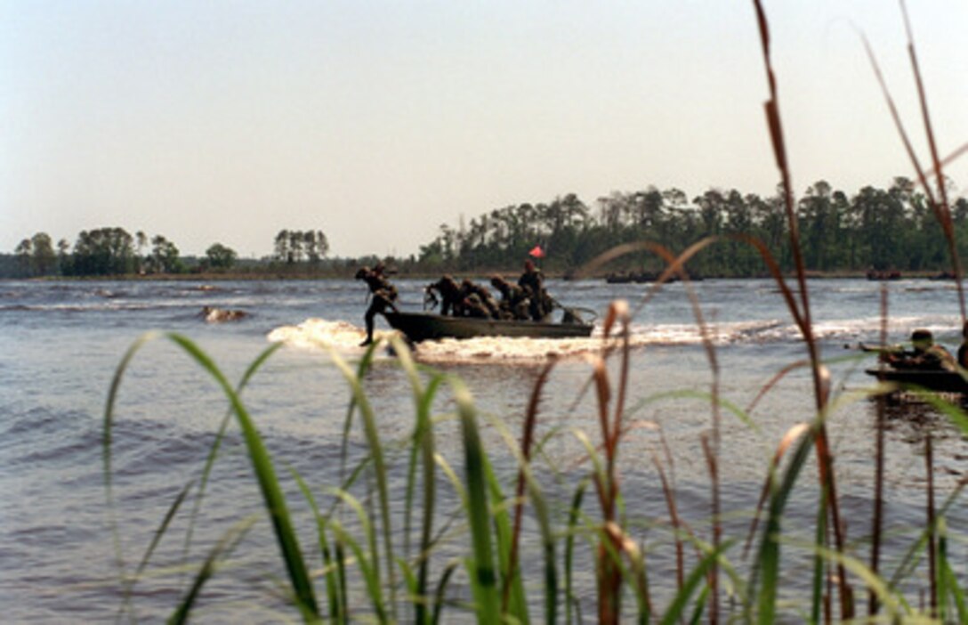 U.S. Marines jump out of Rigid Raiding Craft as they begin a raid on the New River shoreline at Camp Lejeune, N.C., during Riverine Interoperability Operation Exercise '98 on May 14, 1998. The Camp Lejeune exercise, more commonly known as RIOEX, allows forces an opportunity to practice conventional combat operations in a riverine environment. 