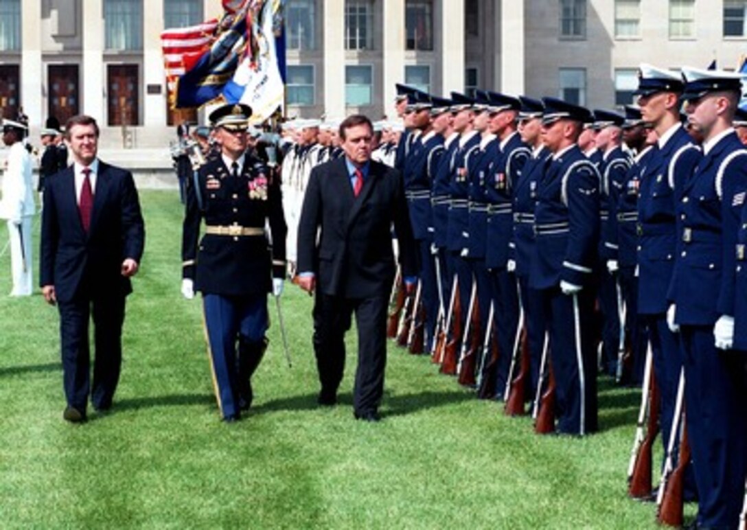 Secretary of Defense William Cohen (left) welcomes his guest, German Minister of Defense Volker Ruehe (right) with an armed forces full honor arrival ceremony at the Pentagon, May 20, 1998. Accompanying the two defense leaders as they inspect the joint services honor guard is the Commander of Troops for the ceremony, Col. Gregory Gardner, U.S. Army. Following the ceremony, Cohen and Ruehe are scheduled to attend a meeting and a working lunch where they will review a range of security issues of mutual interest to both nations. 