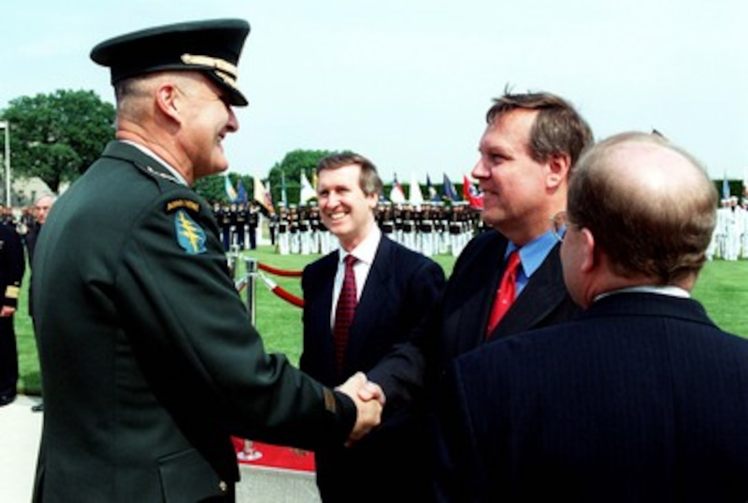 Gen. Henry H. Shelton, U.S. Army, chairman of the Joint Chiefs of Staff (left) greets German Minister of Defense Volker Ruehe (2nd from right) at the conclusion of the military full honor arrival ceremony held for Ruehe at the Pentagon, May 20, 1998. Secretary of Defense William Cohen (center) and Ruehe are scheduled to attend a meeting and a working lunch where they will review a range of security issues of mutual interest to both nations. At the right is Acting Secretary of the Air Force F. Whitten Peters. 