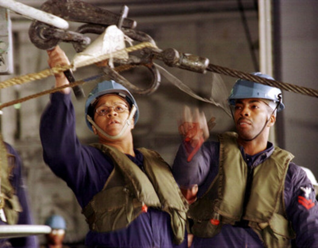Petty Officers 2nd Class Patricia Whitley (left) and Michael Battle disconnect a pelican hook on board the aircraft carrier USS Dwight D. Eisenhower (CVN 69) as they complete an underway replenishment with the USNS Concord (T-AFS 5) on Oct. 11, 1998, in the Mediterranean Sea. Eisenhower is on a six-month deployment to the Mediterranean. The Concord is a Military Sealift Command combat store ship. Both Whitley, from Memphis, Tenn., and Battle, of Kinston, N.C., are Navy Boatswain's Mates. 
