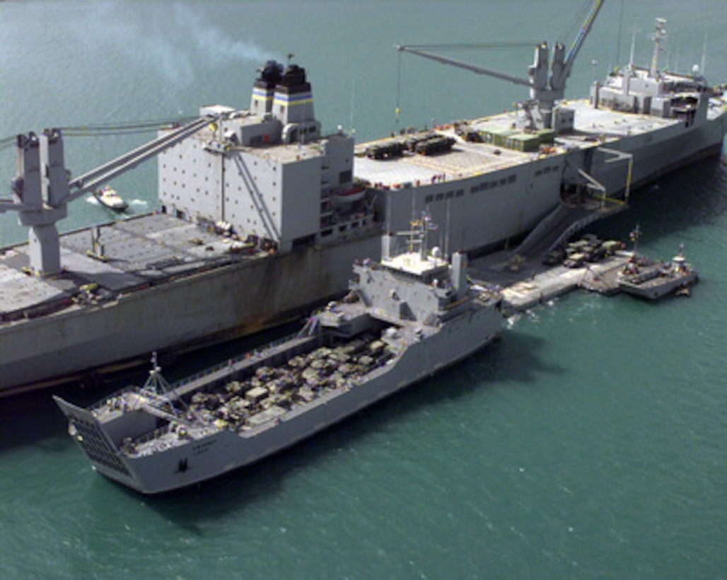 The USNS Pollux off-loads vehicles and equipment for Exercise Foal Eagle '98 while anchored in the harbor of Pusan, Republic of Korea, on Oct. 19, 1998. Attached to the starboard side of the Pollux is a temporary roll-on, roll-off discharge facility which provides a causeway for vehicles to move from the Pollux to a U.S. Army Logistics Support Vessel for transportation to the shore. Foal Eagle '98 is a combined, joint exercise supported by forces from the U.S. and Republic of Korea. In addition to providing hands-on field experience for forces of both nations, Foal Eagle '98 was designed to test rear area protection operations and major command, control and communications systems. Pollux is one of eight Fast Sealift Ships belonging to the Military Sealift Command that have special features allowing them to load and off-load cargo in places lacking normal port facilities. 